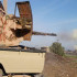 In this image posted on a militant social media account by the Al-Baraka division of the Islamic State group on Tuesday, Feb. 24, 2015, a fighter fires a heavy weapon mounted on the back of a pickup truck during fighting in Tal Tamr, Hassakeh province, Syria. Fierce fighting between Kurdish and Christian militiamen and Islamic State militants is continuing on Wednesday, Feb. 25 in northeastern Syria where the extremist group recently abducted at least 70 Christians. (AP Photo via militant social media account)