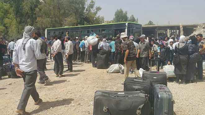 Исламисты и их семьи грузящиеся в автобусы
